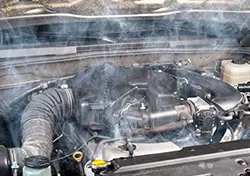 An overheating car engine emitting a ton of smoke