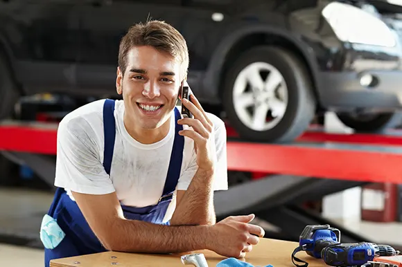 An auto body repair professional holding a phone