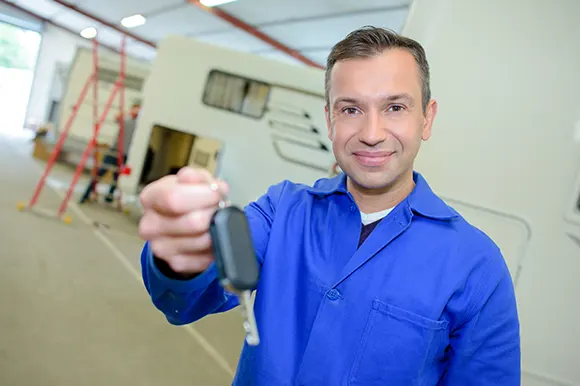 An auto mechanic holding an ignition key