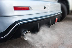 A car's exhaust pipe emitting a ton of smoke