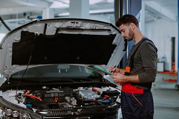 A professional auto technician inspecting the car engine