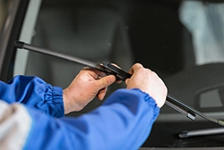 A technician installing a new windscreen wiper